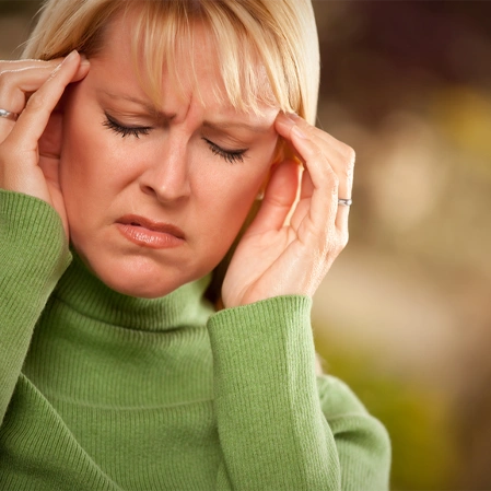 Person Holding Both Temples To Illustrate Headache